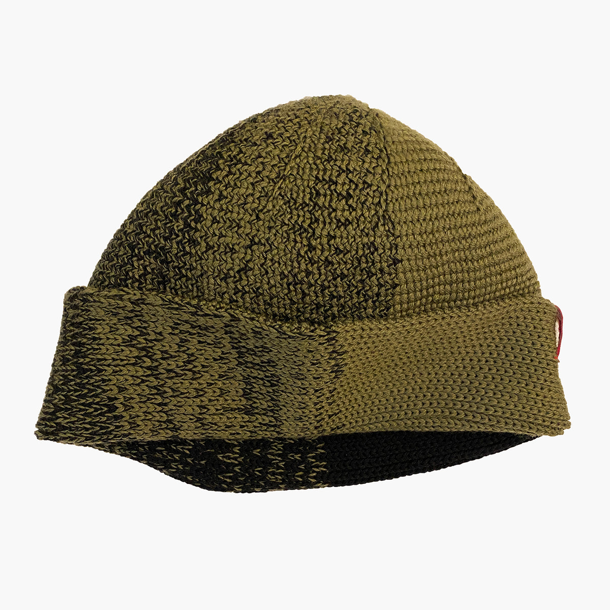 Olive/Schwarze Beanie. Der Rand ist umgeschlagen, wie bei einer Dockermütze. Die Mütze hat einen Farbverlauf, der sich im Kreis wie Tortenstücke verhält. Ein Stück ist Olive-farben ein Stück Schwarz. Dazwischen michen sich die beiden Farben im Farbverlauf von Olive mit etwas Schwarz dann etwas mehr Schwarz usw.