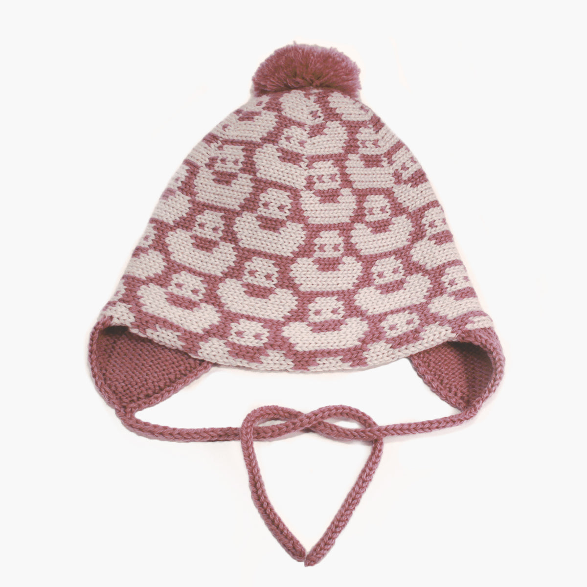 Rosenholz/Wollweiße Mütze für Babies und Kinder mit einem fortlaufenden Muster mit kleinen Enten. Die Babymütze hat eine Bommel und angestrickte Ohrläppchen mit Bändern zum festbinden. Sie ist aufwendig der Kopfform nachgestrickt und paßt sich sehr gut an. Das rote Label mit der kleinen Ente ist hinten angenäht.