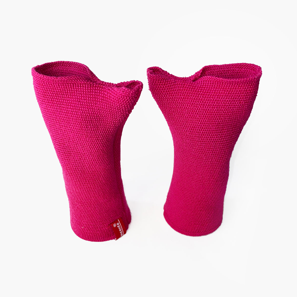 zwei Pink Farbene aufrechtstehende Armstulpen mit abgenähtem Daumenloch. Man sieht das außenliegende Knötchenmuster. Innen sind die Stulpen Glatt techts gestrickt.