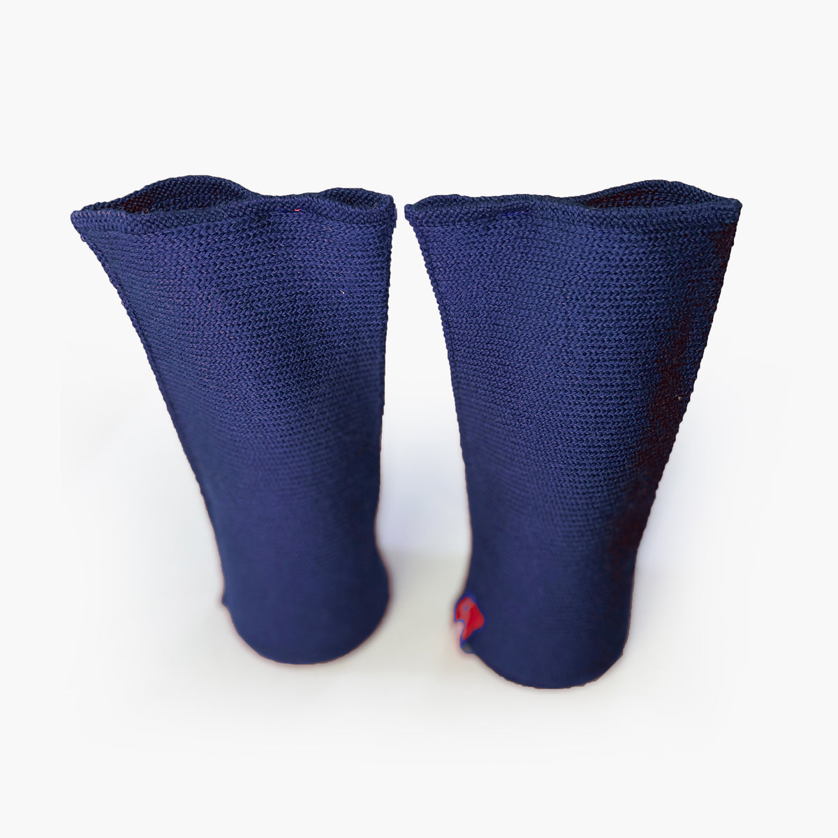 zwei Royalblaue aufrechtstehende Armstulpen mit abgenähtem Daumenloch. Man sieht das außenliegende Knötchenmuster. Innen sind die Stulpen Glatt techts gestrickt.