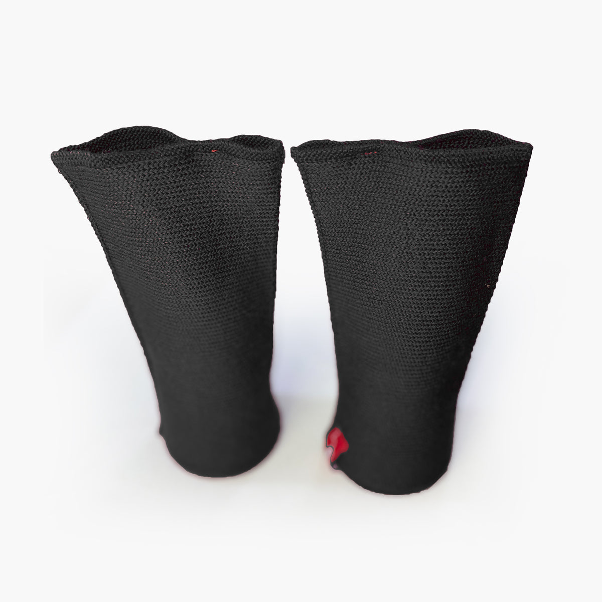 zwei Schwarze aufrechtstehende Armstulpen mit abgenähtem Daumenloch. Man sieht das außenliegende Knötchenmuster. Innen sind die Stulpen Glatt techts gestrickt.