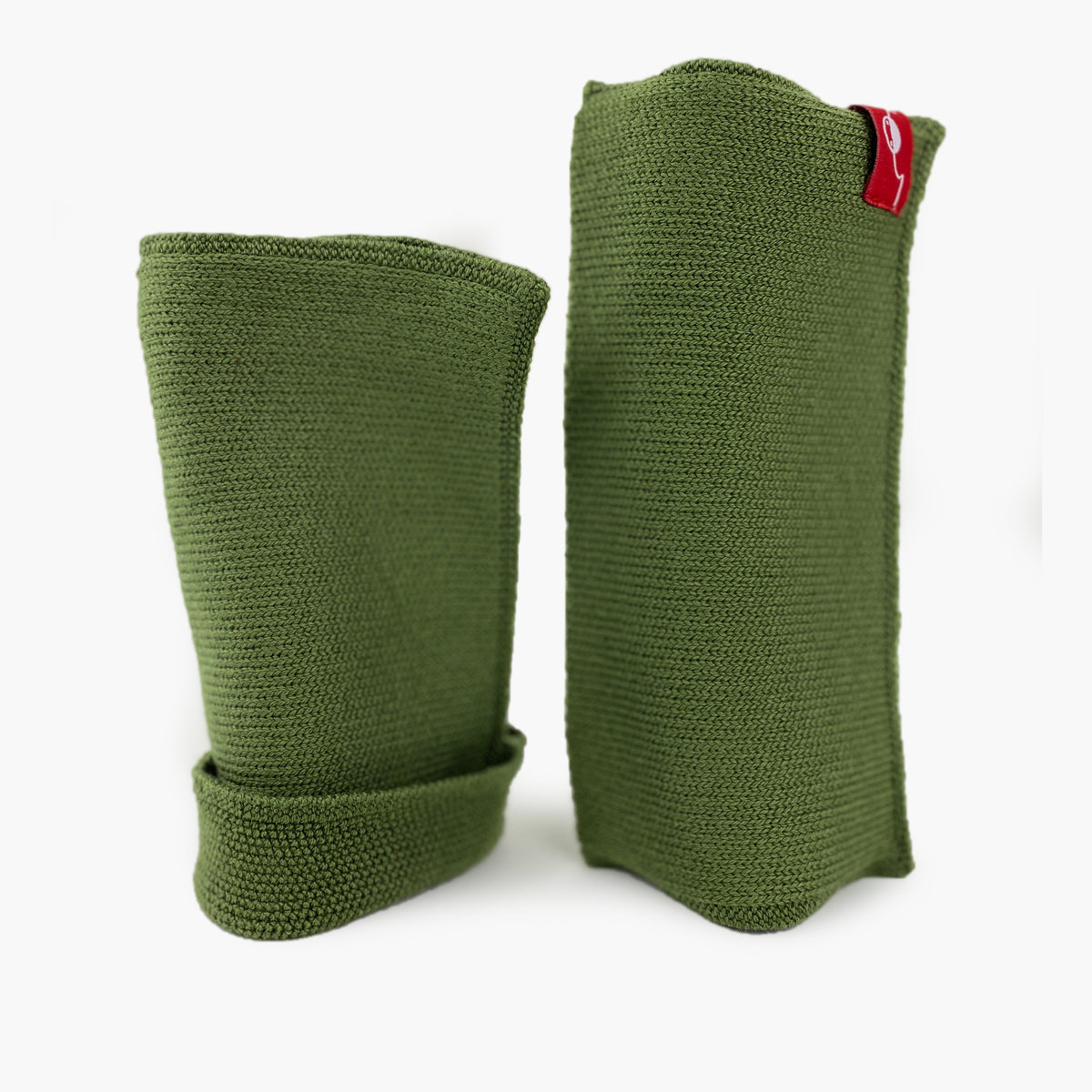 Grüne, aufrecht stehende Armstulpen. Man sieht das außenliegende Glatt Rechts Muster. Innen sind die Stulpen in einem Feinen Knötchenmuster gestrickt, man kann sie auch Innsideout tragen