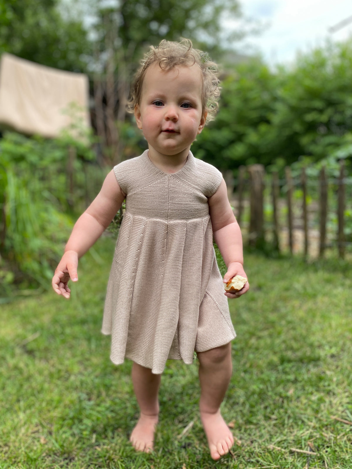 Ein kleines Mädchen trägt ein Sommerkleid von vincente aus Tencel/Lyocell gestrickt in Beige