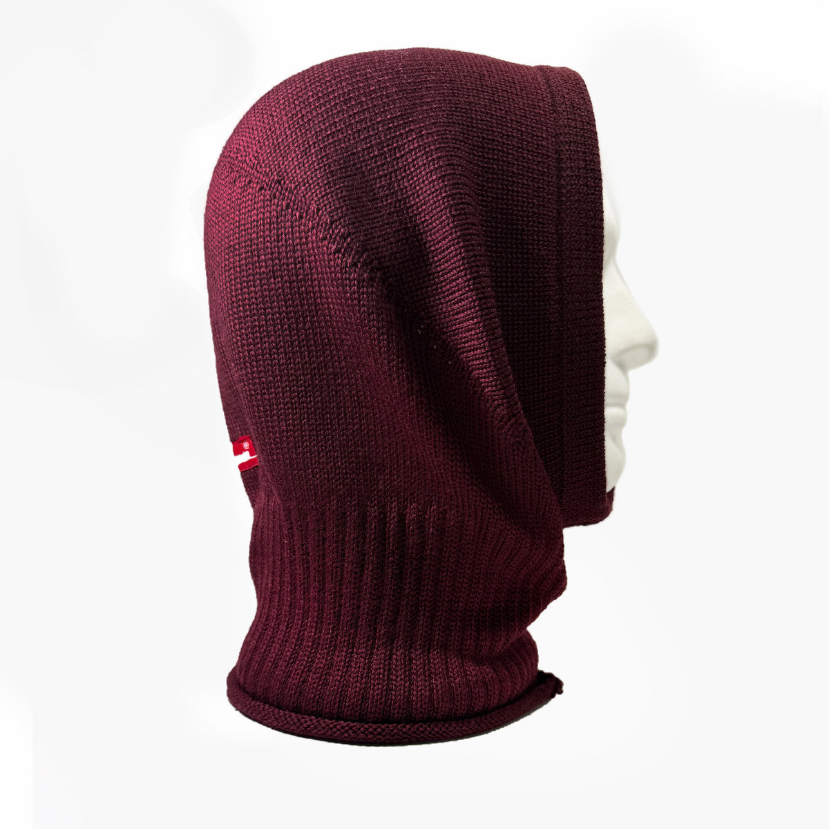 Gestrickte Mütze, die wie eine Kaputze den Kopf und Hals umhüllt. In Bordeauxrot