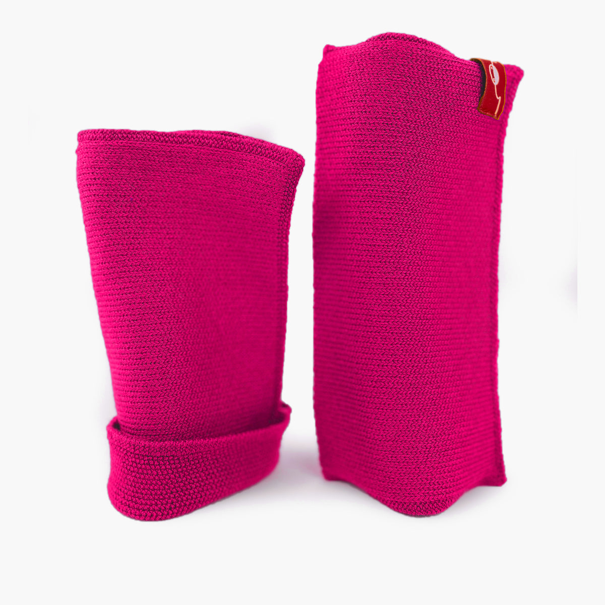 Pinke, aufrecht stehende Armstulpen. Man sieht das außenliegende Glatt Rechts Muster. Innen sind die Stulpen in einem Feinen Knötchenmuster gestrickt, man kann sie auch Innsideout tragen