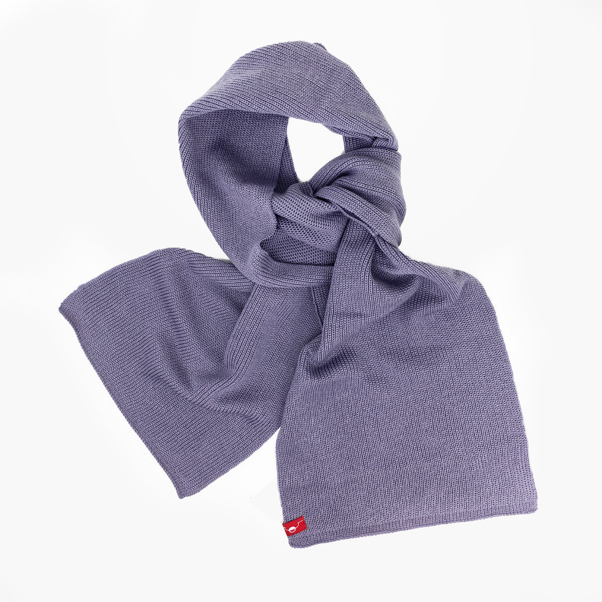 Lilaner, gestrickter Schal im Fangpatentmuster. Eine Seite sieht glatt rechts gestrickt, die andere Seite sieht aus wie minikleine Muscheln oder Punkte. Der Wollschal ist zu einem Haufen drapiert, so sieht man den weichen Fall.