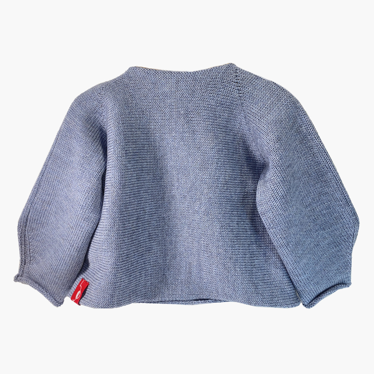 Rückseite der Graublauen Babyjacke mit seitlicher Knöpfung, auch Schlüttli genannt. Die Strickjacke ist aus Bio-Merinowolle gestrickt
