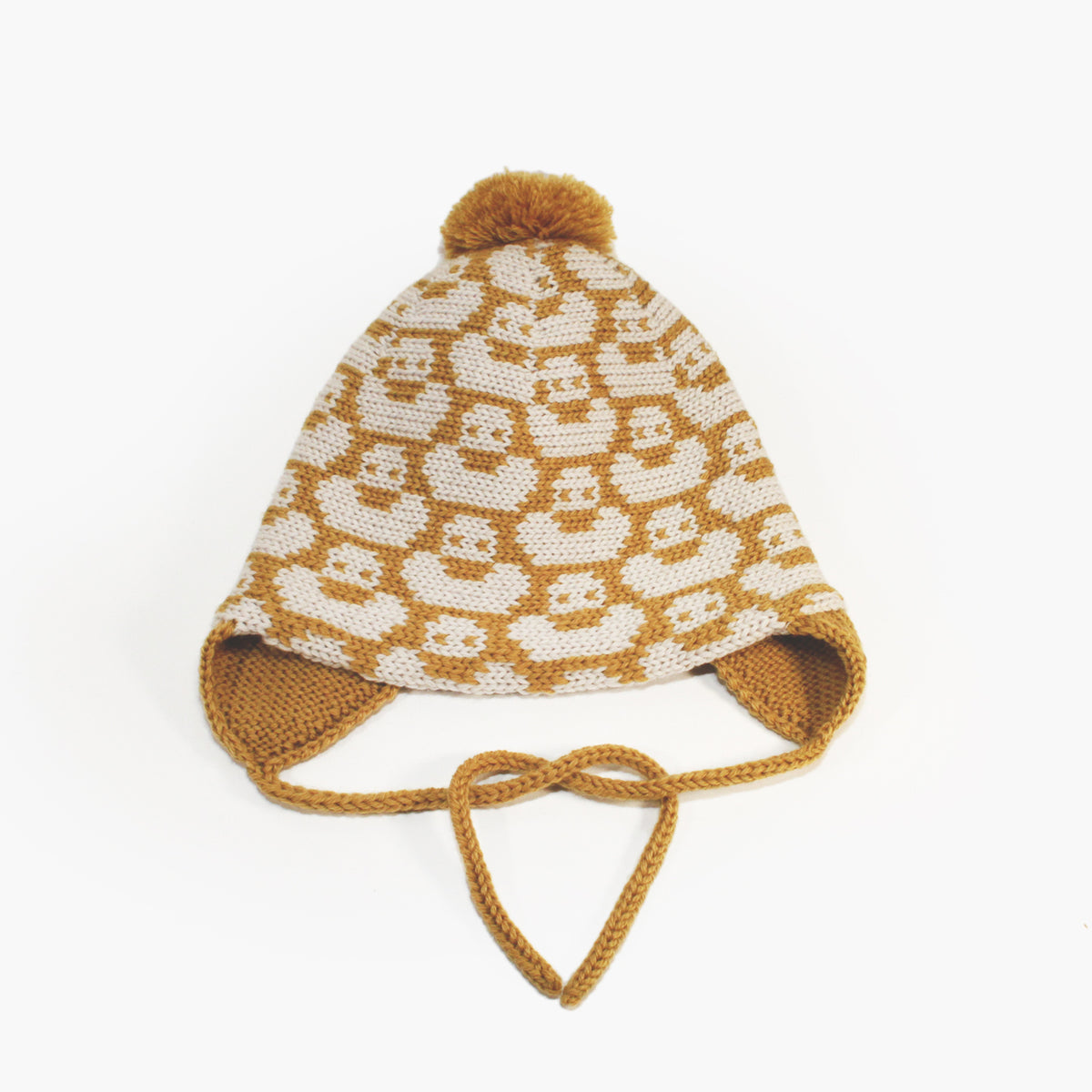 Gold/Wollweiße Mütze für Babies und Kinder mit einem fortlaufenden Muster mit kleinen Enten. Die Babymütze hat eine Bommel und angestrickte Ohrläppchen mit Bändern zum festbinden. Sie ist aufwendig der Kopfform nachgestrickt und paßt sich sehr gut an. Das rote Label mit der kleinen Ente ist hinten angenäht.