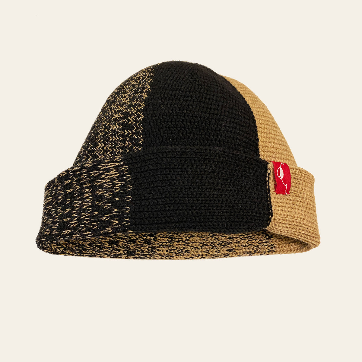Karamel/Schwarze farbene Beanie. Der Rand ist umgeschlagen, wie bei einer Dockermütze.  Die Mütze hat einen Farbverlauf, der sich im Kreis  von Karamel mit etwas Schwarz dann etwas mehr Schwarz usw. verhält.