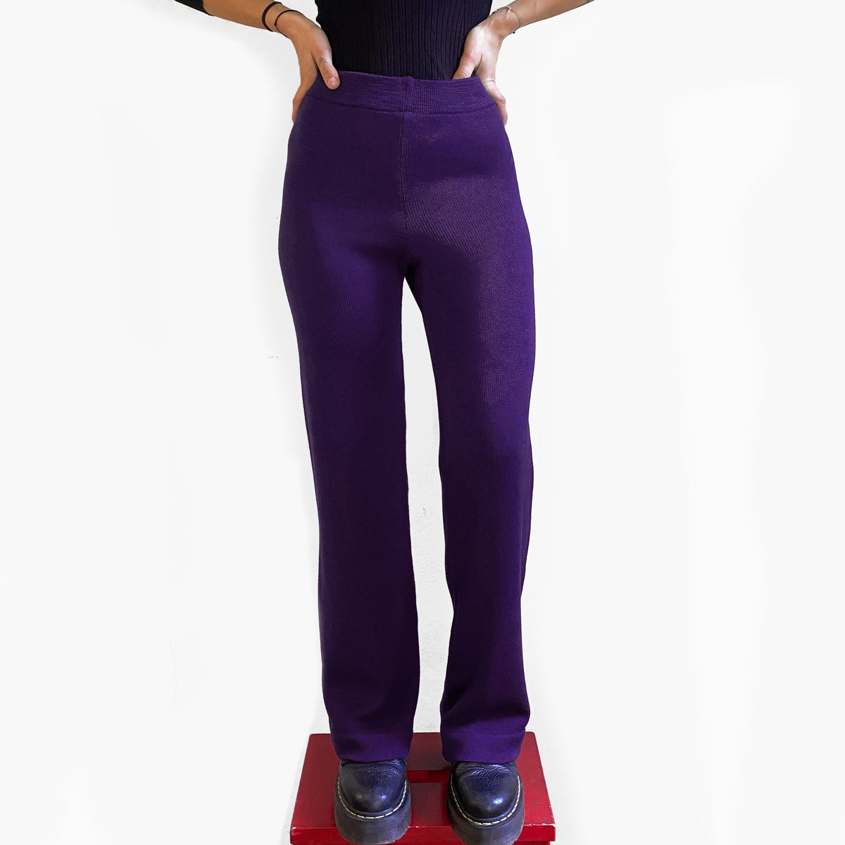 Ein Model vom Bauchnabel abwärts trägt eine Strick-Hose in Aubergine 