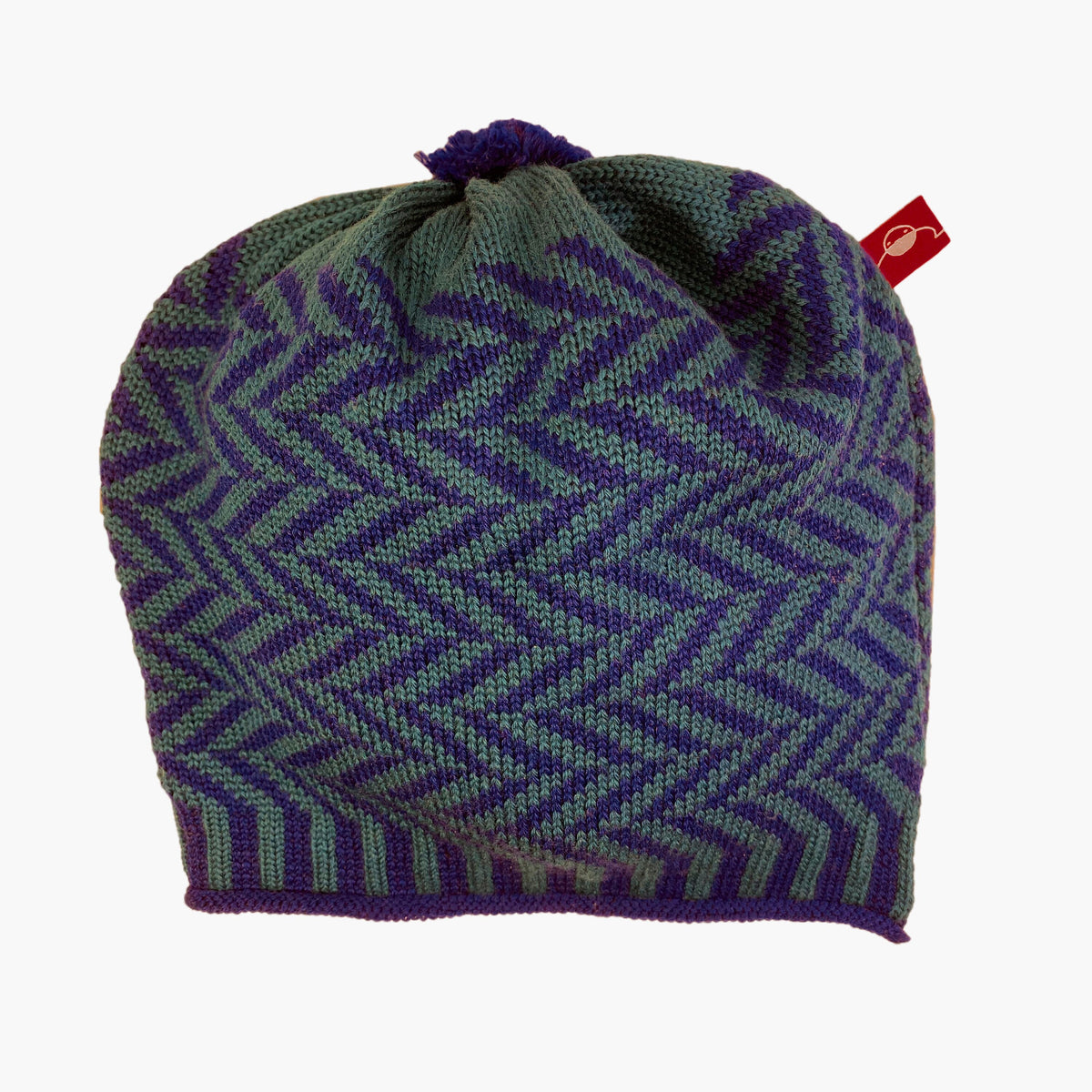 Petrol/Royalblaue  Beanie-Mütze aus Merinowolle mit längs gestreiften elastischem Bündchen. Die Mütze ist im klassichem Fischgrätmuster gestrickt und hat eine kleine unauffällige Bommel.