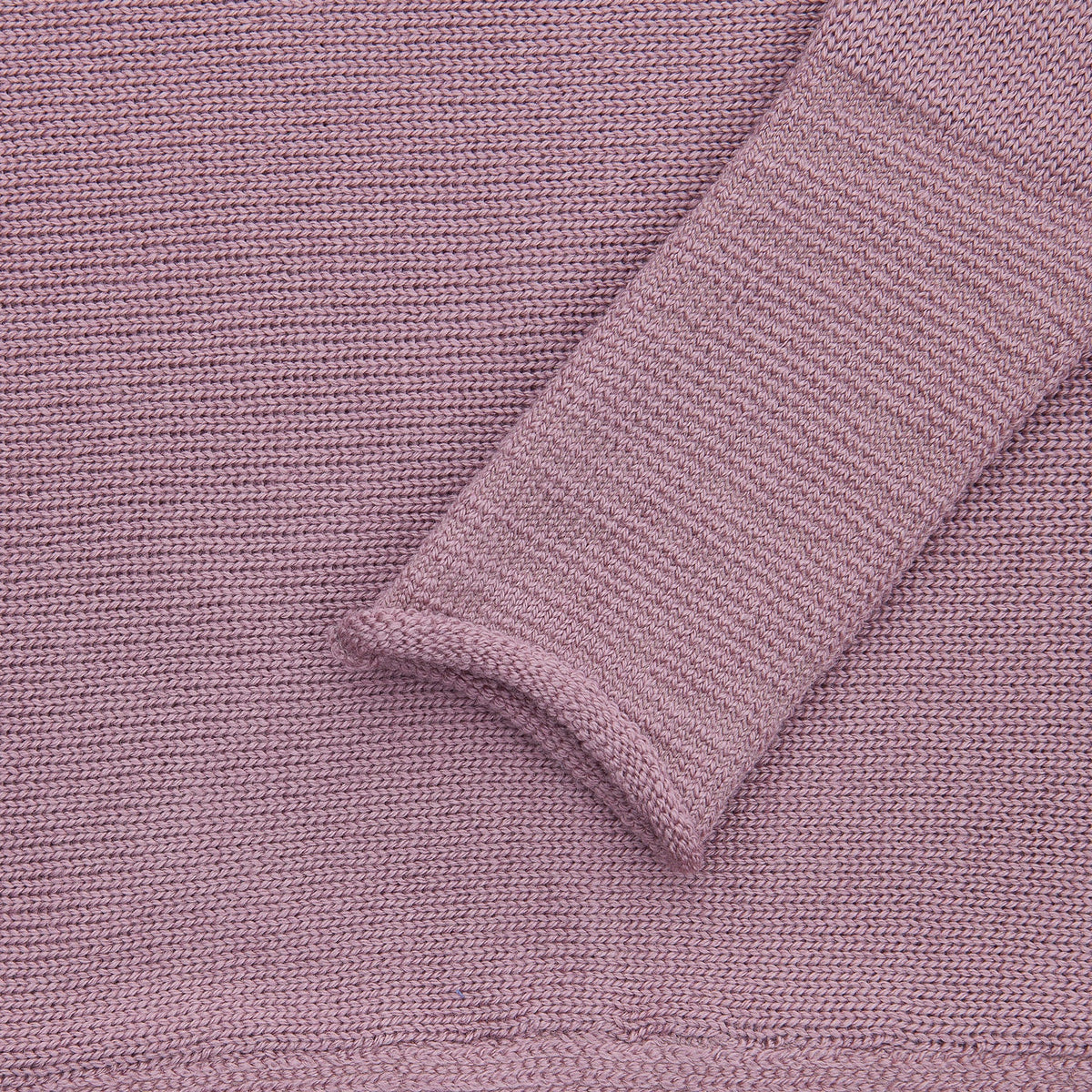 Detailansicht des Rosenholz Farbenern gestrickten Pullover mit angeschnittenen Ärmeln. Man sieht das Ärmelbündchen.