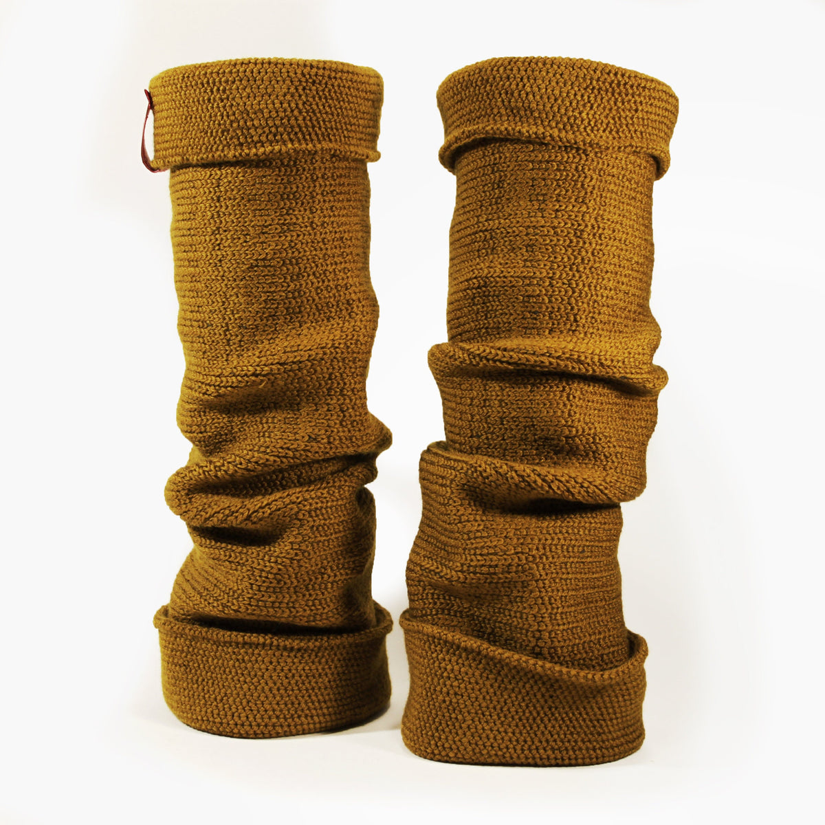 Bronce farbene aufrecht stehende Beinstulpen. Man sieht das außenliegende Glatt Rechts Muster. Sie sind umgeschlagen so sieht man das Innere feine Knötchen-Muster. Man kann sie auch Innside-out tragen. Das Rote/Weiße vincente-Logo ist angenäht.